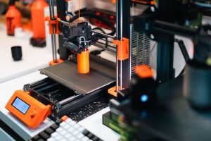 pexels photo 31357903 3D printer operating in a workshop, creating a prototype with orange accents.